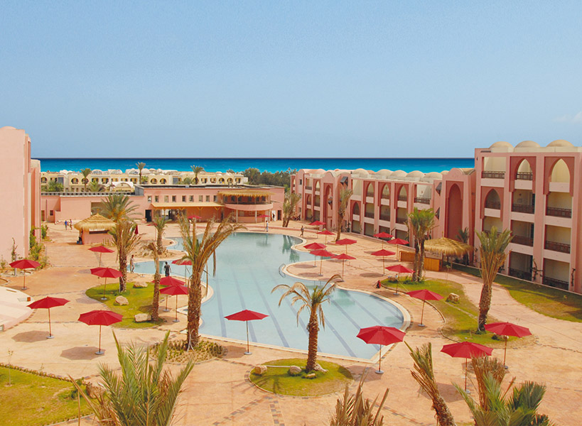 Außenansicht der Hotelanlage Lella Meriam mit Pool, Palmen und dem Meer im Hintergrund