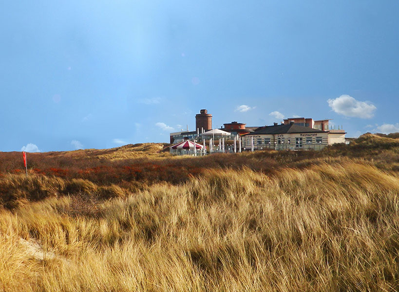 Außenansicht auf das Restaurant Strandhalle Juist mit Dünenlandschaft