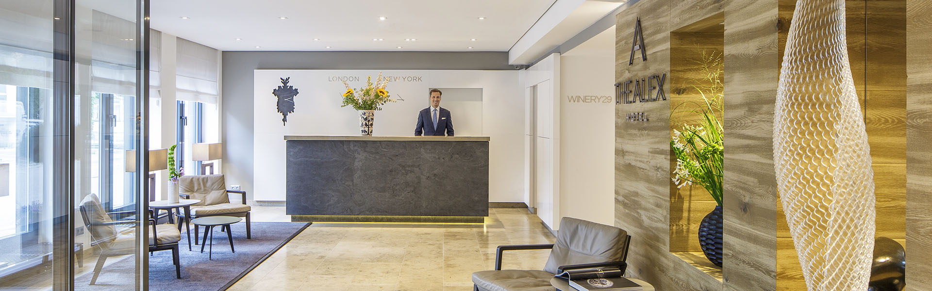 Innenansicht der Rezeption von The Alex Hotel mit Rezeptionist