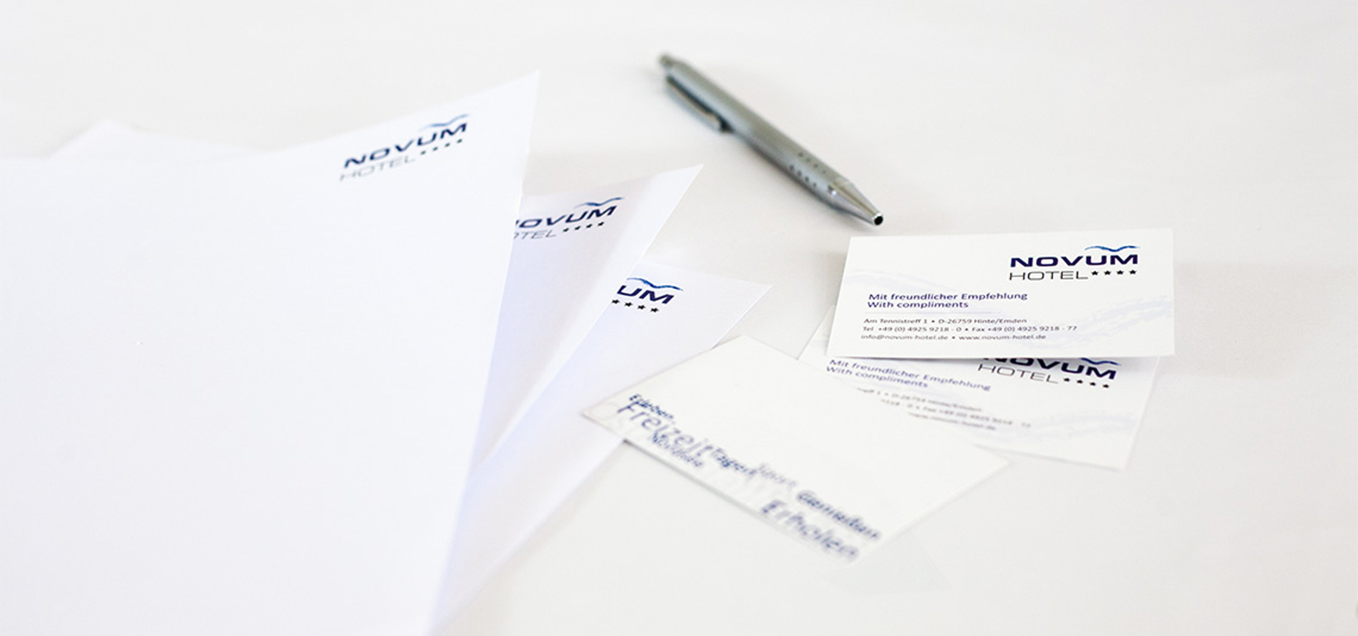 Ansicht auf drei Briefpapiere und die Vorder- und Rückseite der Visitenkarte vom Hotel Novum